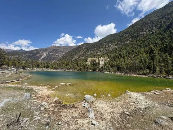 Mringkyo Green Lake near Pisang, Manang, Nepal, surrounded by alpine terrain and mountains.