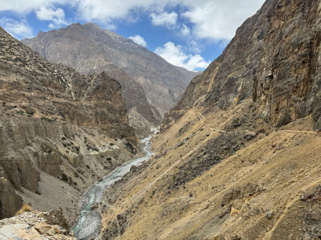 Barren, brown, towering Yongmoso Hill with the Nar River flowing at its base in the Nar Phu Region.
