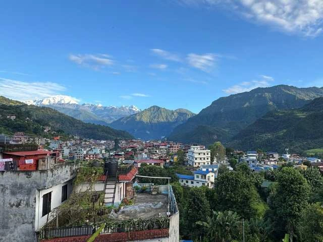 Besisahar city in Nepal with Lamjung Peak visible in the background, surrounded by lush greenery.