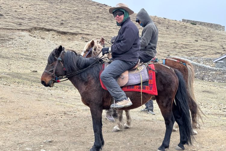Traveler horse riding through the rugged trails of Nar Phu Valley, Nepal.