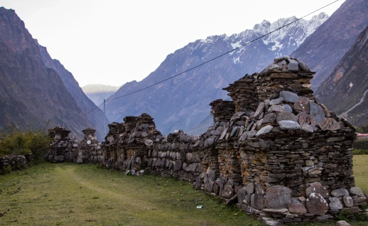 Tsum Valley, a beyul, with eight stone-built chortens surrounded by towering, rugged, green hills.